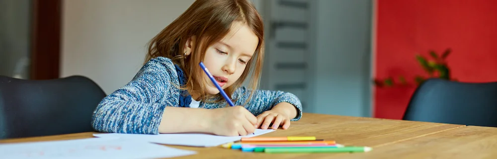 Pige tegner med farveblyanter