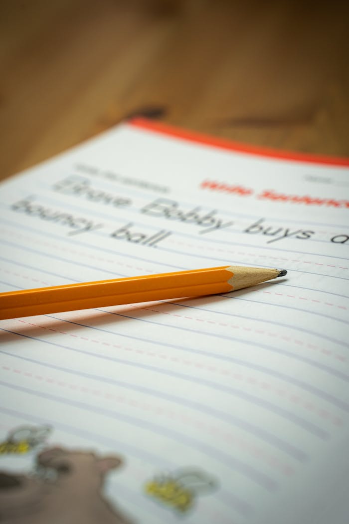 Close-up of a pencil on a child's writing practice notebook, emphasizing education and learning.