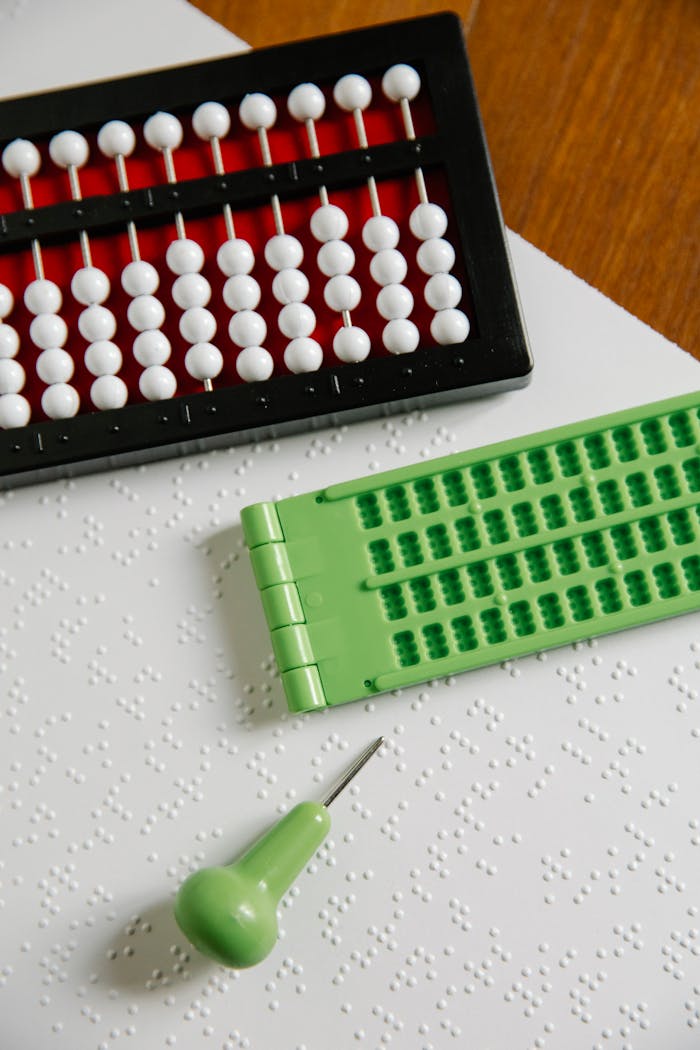 Abacus and Braille tools on a textured surface, perfect for inclusive education themes.